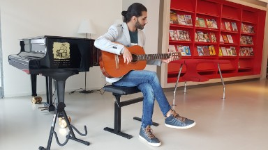 Rami stemt de gitaar alvast voor de eerste gitarist die langskomt